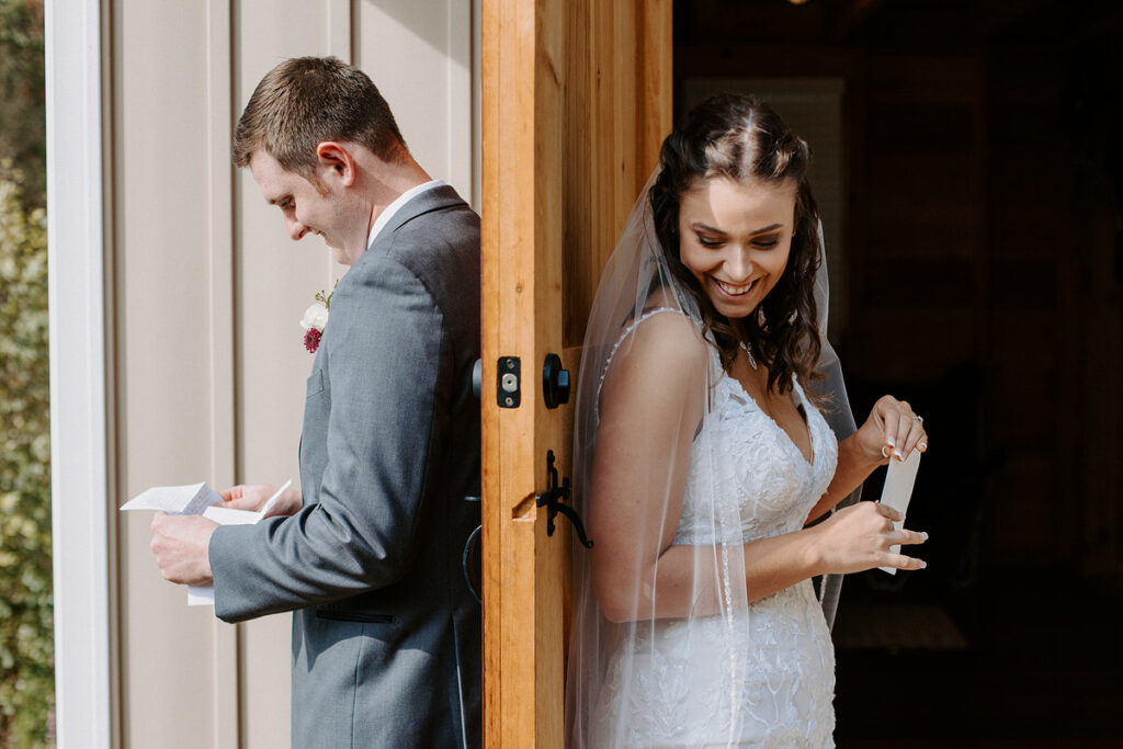 Wedding couple standing on either side of a door from each other. 