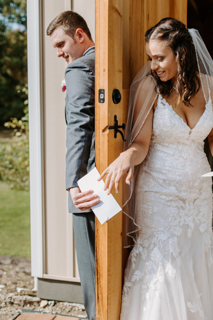 A groom passing a letter around a door to his bride. 