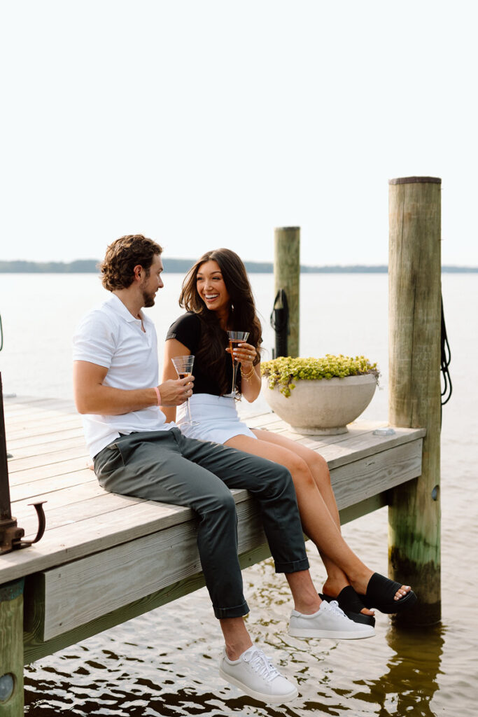 A couple sitting on a pier talking together. 