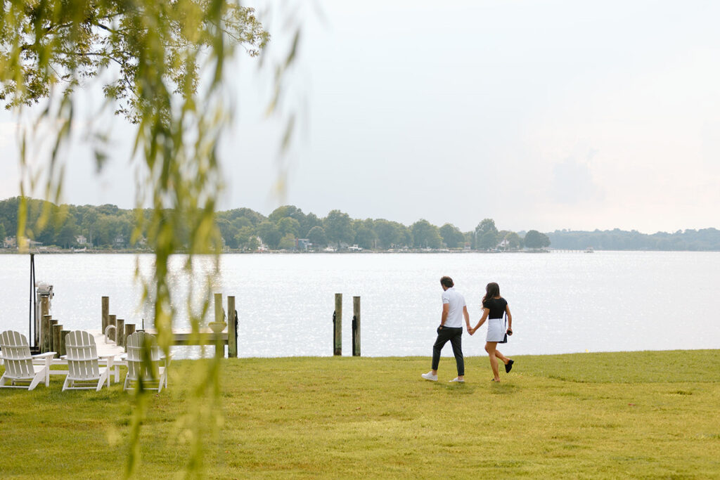 A couple waking along a field towards the water. 
