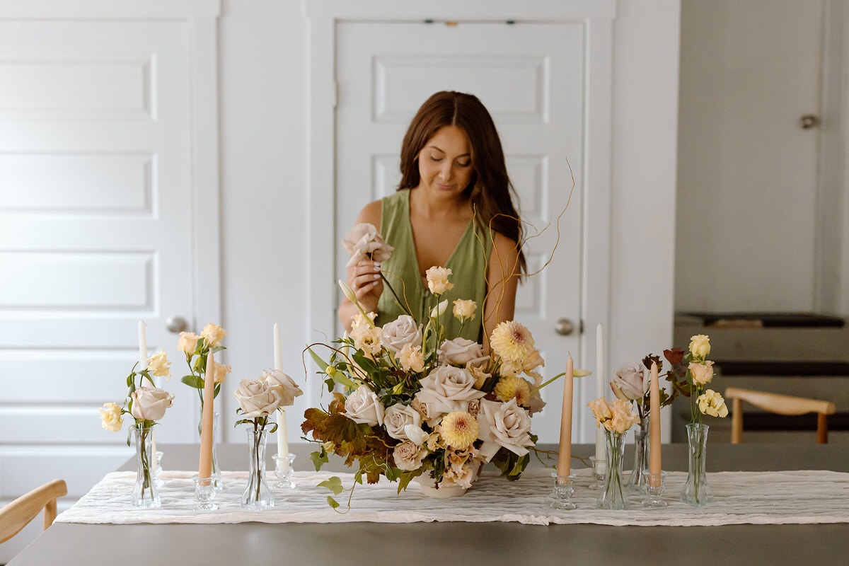 Florist photography showing a woman putting together a flower arrangement.