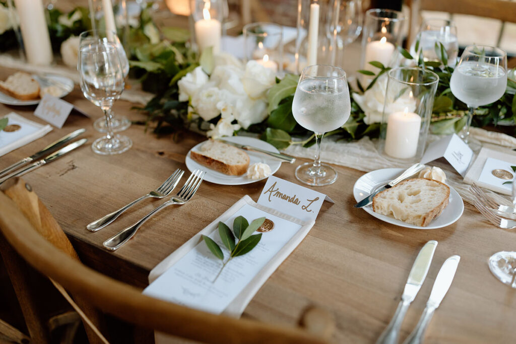 A close up view of a wedding reception table with break on small plates. 
