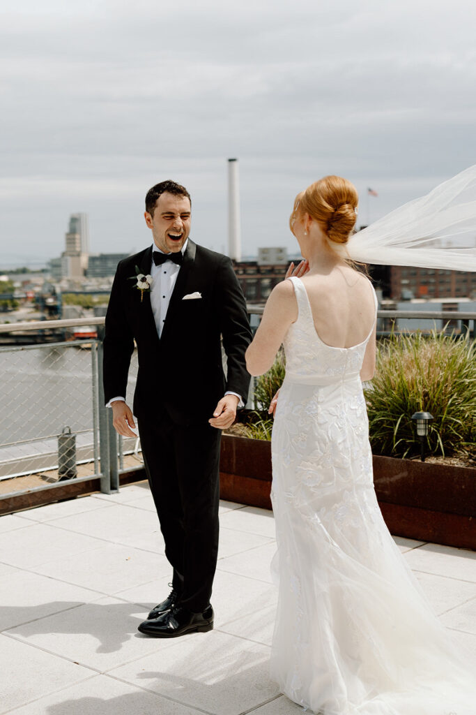 A wedding couple during their first look on a rooftop. 