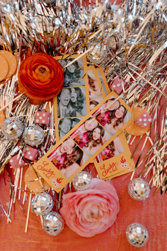 Close up of photo strips surrounded by disco balls and flowers.