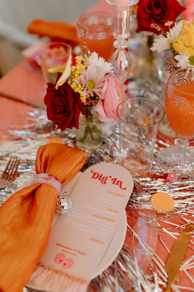 Close up of a place setting on a colorful table for a wedding.