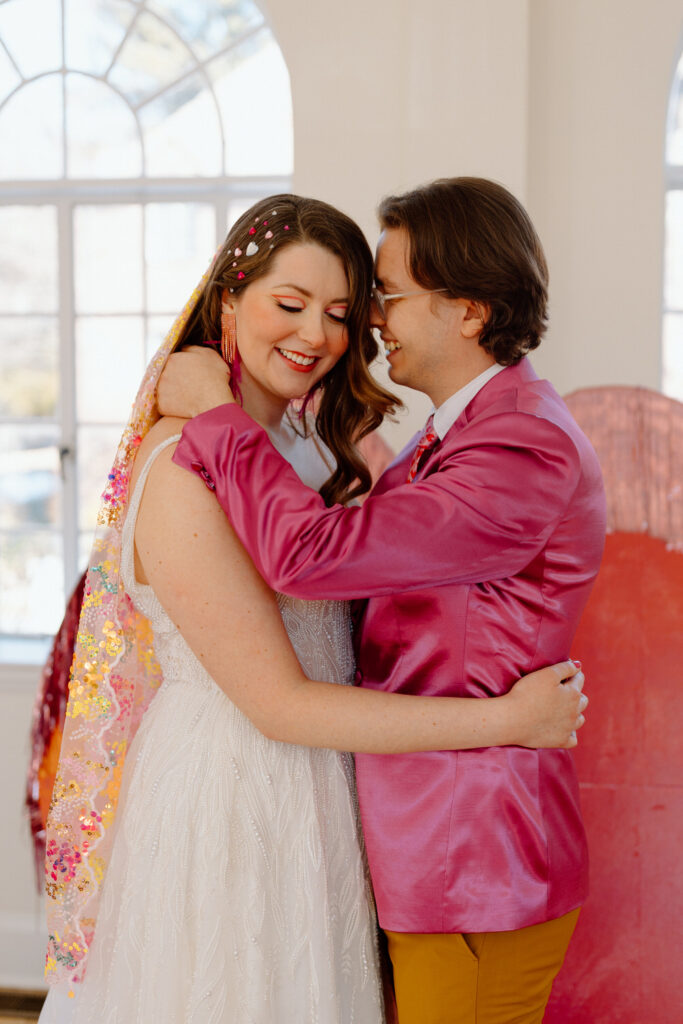 A couple holds one another in colorful wedding attire.