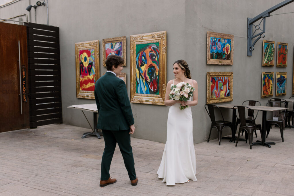 A first look between two partners on their wedding day outdoors.