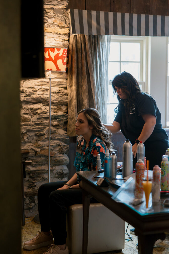 A to-be-wed sits in a chair getting their hair ready.