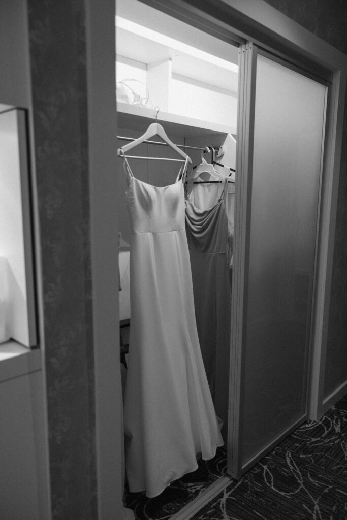 Dresses hang on hangers in a closet.